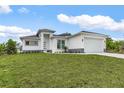 Single Gathering home featuring a well-maintained lawn, modern exterior, and a two-car garage at 165 Ingram Blvd, Rotonda West, FL 33947