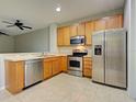 Bright kitchen with stainless steel appliances, tile floors and wooden cabinets at 1273 Jonah Dr, North Port, FL 34289