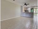 Spacious living room with tiled floors, ceiling fan and access to a screened porch at 1273 Jonah Dr, North Port, FL 34289