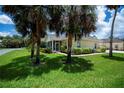 Back exterior view of home showcasing screened-in porch and well-kept lawn at 1318 Red Oak Ln, Port Charlotte, FL 33948
