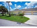 Side view of the home showing the attached garage, manicured lawn, and walkway to the front entrance at 1318 Red Oak Ln, Port Charlotte, FL 33948