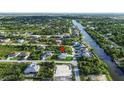 Aerial view showing the property's location in a neighborhood near a canal and surrounding greenery at 13406 Chenille Dr, Port Charlotte, FL 33981