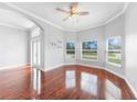 Bright living room featuring hardwood floors, arched doorways, and large windows at 1523 Napoleon Rd, North Port, FL 34288