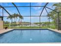 A screened-in pool boasts serene waterfront views of a canal at 1527 Aqui Esta Dr # 3, Punta Gorda, FL 33950