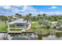 Tranquil home featuring screened lanai, lush yard, boat dock, and waterfront views at 15652 Havana Cir, Port Charlotte, FL 33981