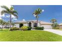 Beautiful single-story home with well-manicured lawn, mature palms, and a welcoming facade at 167 & 169 Marker Rd, Rotonda West, FL 33947