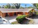Spacious single-story home with an orange exterior, a boat, mature landscaping, and a patio at 2131 Heasley Rd, Englewood, FL 34223
