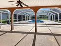 Covered outdoor patio provides shade and views of the screened-in private pool and surrounding greenery at 2131 Heasley Rd, Englewood, FL 34223