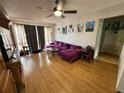 Living room featuring hardwood floors, a ceiling fan, and a large purple sectional sofa at 2174 Schwalbe Way, Sarasota, FL 34235