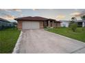 Charming home featuring a long concrete driveway, attached garage, and a well-manicured lawn at 23101 Hillsdale Ave, Port Charlotte, FL 33954