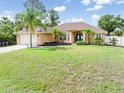 Inviting single-story home featuring double front doors, lush landscaping, and a well maintained lawn at 2373 Chartwell Ave, North Port, FL 34288
