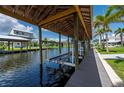 View of the boat lift and dock with quick access to open water and a great home in the distance at 24261 Captain Kidd Blvd, Punta Gorda, FL 33955