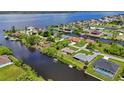 Scenic aerial view of waterfront homes nestled along a canal with lush landscaping and waterfront access to the bay at 2467 Herron Ter, Port Charlotte, FL 33981