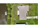 Overhead aerial view showcasing the home's roof, backyard patio, canal access, and boat dock, highlighting waterfront living at 2467 Herron Ter, Port Charlotte, FL 33981