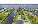 Picturesque aerial view of homes along a canal with lush greenery, showcasing waterfront living near a bay at 2467 Herron Ter, Port Charlotte, FL 33981