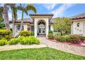 Close-up of the front entrance with arched doorway and lush landscaping at 250 Freeport Ct, Punta Gorda, FL 33950