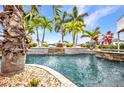 Resort-style pool area with rock features and lush tropical landscaping at 250 Freeport Ct, Punta Gorda, FL 33950