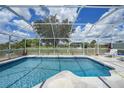 Inviting screened-in pool with clear blue water, ample seating, and scenic backyard views on a sunny day at 37 Pepe Ct, Punta Gorda, FL 33983