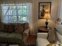 Comfortable living room with cozy seating, a view through a large window, and decorative elements at 4823 Foxhall Rd, North Port, FL 34288