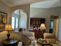 Cozy living room featuring comfortable seating, warm lighting, and a view into an adjacent bedroom at 4823 Foxhall Rd, North Port, FL 34288