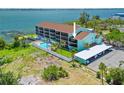 An exterior view of the turquoise condo building showing pool, boat docks, and covered parking at 53 W Bay Heights Rd # 307, Englewood, FL 34223