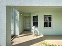 Inviting covered entrance with mint-green exterior, stylish wall lamp, and convenient small table near the door at 5725 Greenwood Ave # 5103, North Port, FL 34287