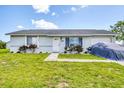Inviting home featuring a lush green lawn, neat landscaping, bright exterior and an attached garage at 5983 Hobhill Ave, North Port, FL 34287