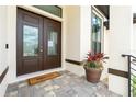 Inviting double front doors, a charming 'Hello' mat, and a beautiful potted plant create a welcoming entrance at 609 Monaco Dr, Punta Gorda, FL 33950