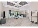 Open-concept living room boasts modern ceiling detail, light tile flooring, and seamless access to the outdoors at 609 Monaco Dr, Punta Gorda, FL 33950