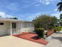 Property featuring a brick front porch and lush landscaping, ready for new residents at 617 W Olympia Ave, Punta Gorda, FL 33950