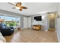 Bright living room with tile floors, gray walls, a ceiling fan, and a large window at 6382 Cutler Ter, Port Charlotte, FL 33981