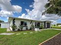 Well-maintained single-story home showcasing lush landscaping, a manicured lawn, and a charming brick trim at 6483 Fabian Rd, North Port, FL 34287