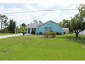A light-blue single-story home with well-manicured lawn and landscaped garden at 6689 Gasparilla Pines Blvd, Englewood, FL 34224