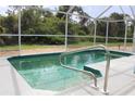 An enclosed pool features a small step-in area and a silver-colored handrail at 6689 Gasparilla Pines Blvd, Englewood, FL 34224