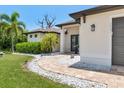Home's front entrance features a paver walkway, tasteful landscaping, and decorative stone accents for a welcoming approach at 8081 Dimstead St, Port Charlotte, FL 33981