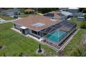 Aerial view of the property with a screened-in pool and well-maintained lawn at 871 Columbia St, Port Charlotte, FL 33948