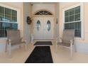 Inviting front porch with double doors, seating, and decorative accents at 871 Columbia St, Port Charlotte, FL 33948
