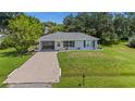 An aerial view of a cozy home with a well-kept lawn and an attached carport, surrounded by mature trees at 879 E Seminole Dr, Venice, FL 34293