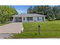 Charming single-story home featuring a well-maintained lawn and cozy curb appeal with an attached carport at 879 E Seminole Dr, Venice, FL 34293