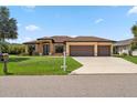 Beautiful single-story home with a well-manicured lawn and a three-car garage on a sunny day at 1275 Blue Lake Cir, Punta Gorda, FL 33983