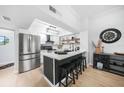 Modern kitchen featuring stainless steel appliances, a stylish island with seating, and an eye-catching light fixture at 1375 Saxony Cir # 124, Punta Gorda, FL 33983
