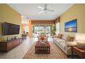 Bright living room featuring tile floors, comfortable seating, and seamless access to outdoor patio at 14311 Reserve Ct, Port Charlotte, FL 33953