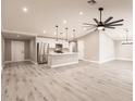 Bright open-concept living area with high ceilings, modern lighting fixtures, and light gray wood-look flooring at 16403 Perdida Ct, Punta Gorda, FL 33955