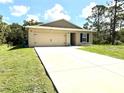Charming single-story home featuring a well-manicured lawn and a two-car garage at 17344 York Ave, Port Charlotte, FL 33948
