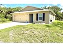 Single story home featuring a well-manicured lawn and a two-car garage at 17344 York Ave, Port Charlotte, FL 33948