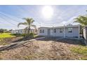 Charming single-story home featuring a partially dirt lawn and mature palm tree in a sunny neighborhood at 175 Rodgers Ne Ave, Port Charlotte, FL 33952