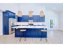 Modern kitchen boasts a center island, stylish pendant lighting, and sleek appliances, great for entertaining guests at 18610 Fort Smith Cir, Port Charlotte, FL 33948