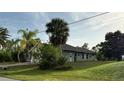This single story home's backyard features lush grass and a view of the back of the home and part of the roof at 2143 Santonian Ter, North Port, FL 34286