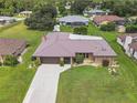 Aerial view of single-story home featuring a brown metal roof, well-manicured lawn, and inviting curb appeal at 21460 Sheldon Ave, Port Charlotte, FL 33952