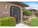 Front entrance with decorative screen door and lush landscaping providing curb appeal at 21460 Sheldon Ave, Port Charlotte, FL 33952